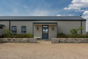 Contemporary farmhouse entrance with low stone clad walls