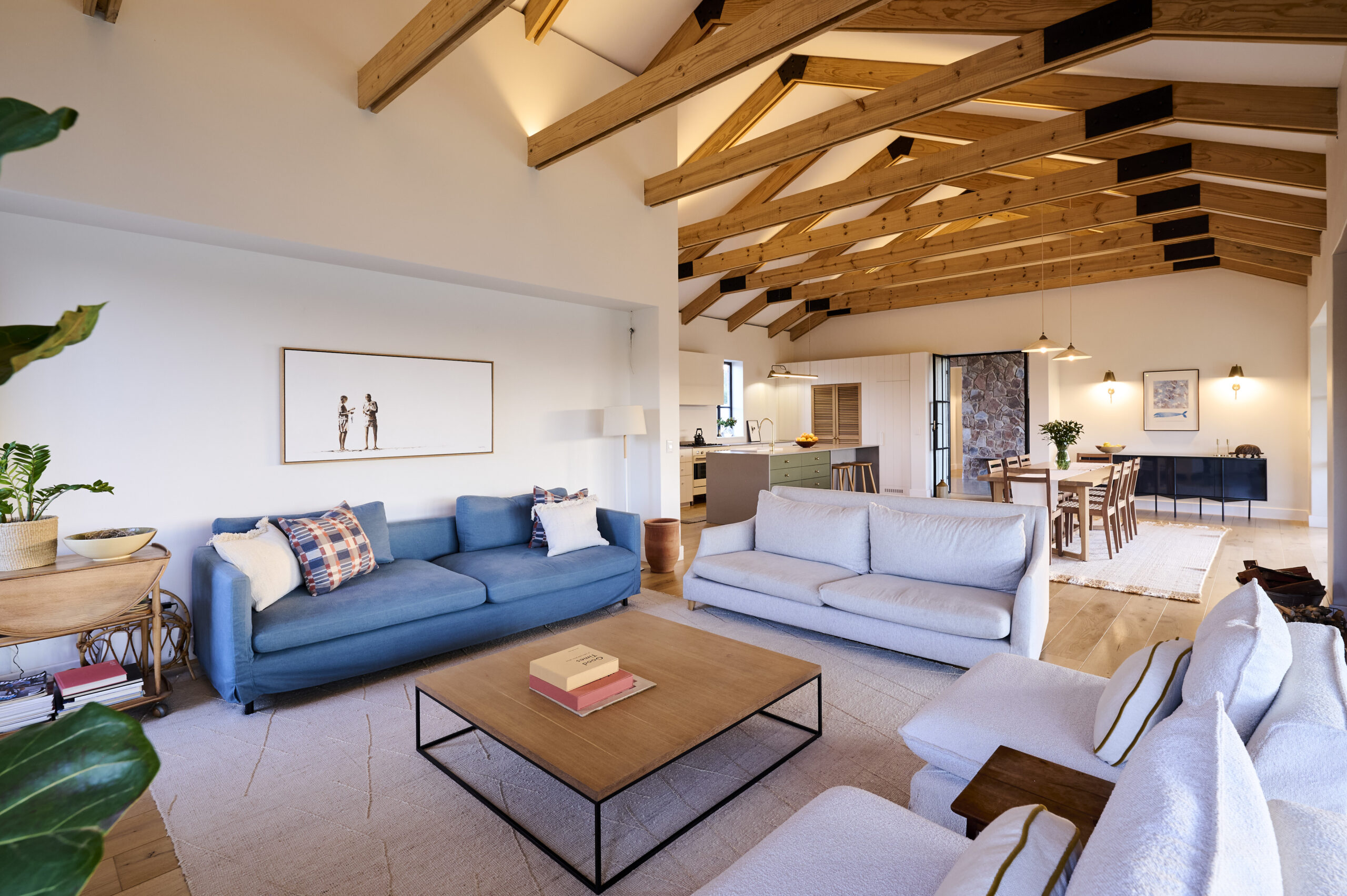 Contemporary living room layout featuring a deep blue sofa and white armchairs around a coffee table.