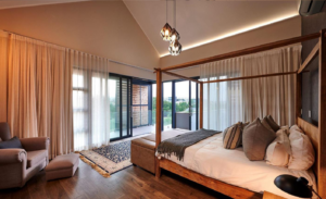 Upper-floor bedroom with large sliding doors leading to a balcony overlooking the Waterfall Estate green belt.