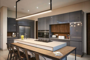 Wide angle shot of sleek, minimalist kitchen with a large island and integrated appliances designed for family living.