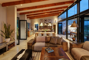 Detail of an interior room with high vaulted ceilings, exposed wooden beams, and industrial-style black window frames.