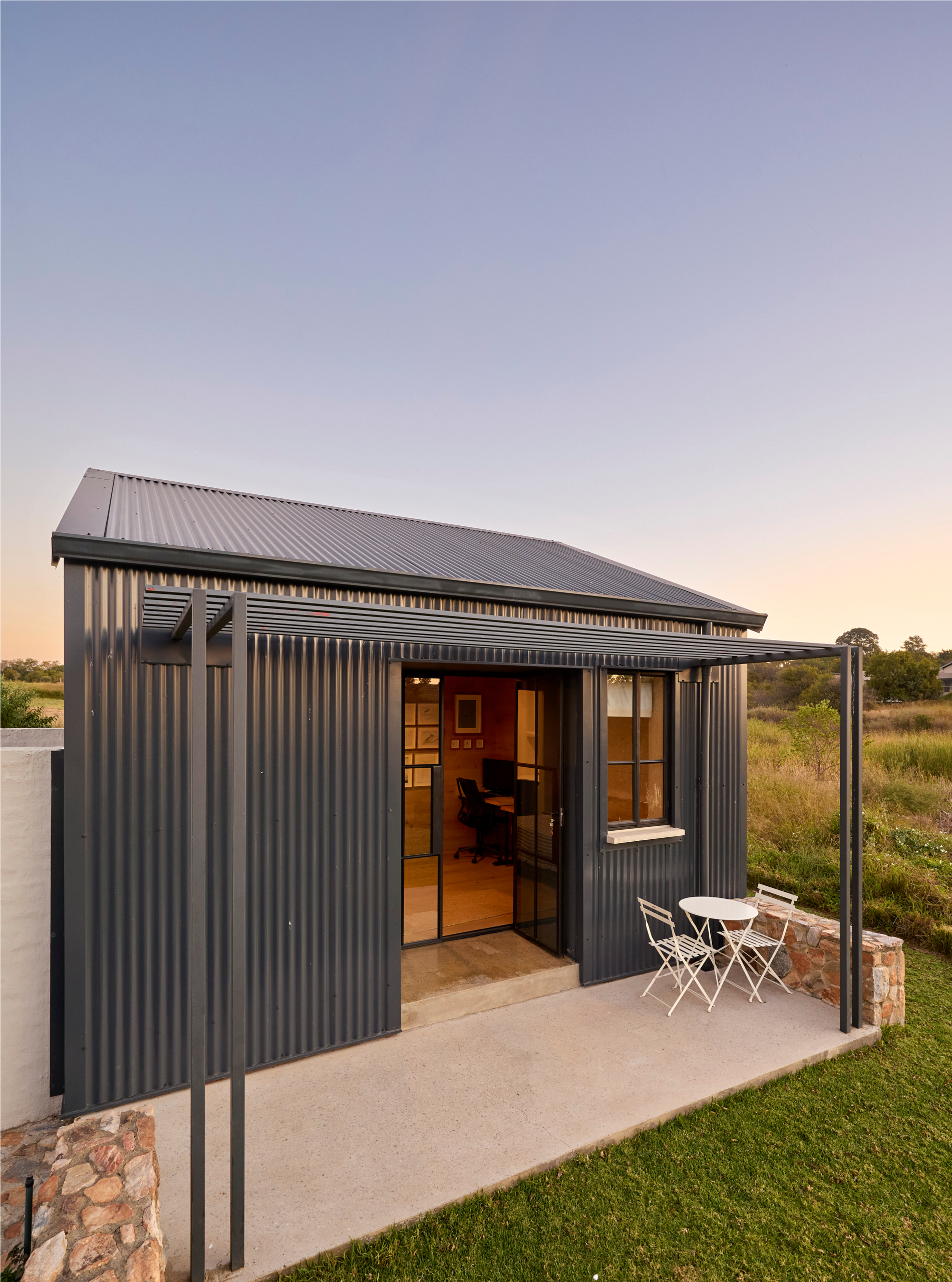 corrugated-metal-cottage-studio-patio Splash pool outside main bedroom with timber and steel pergola and deck stairs leading to private garden