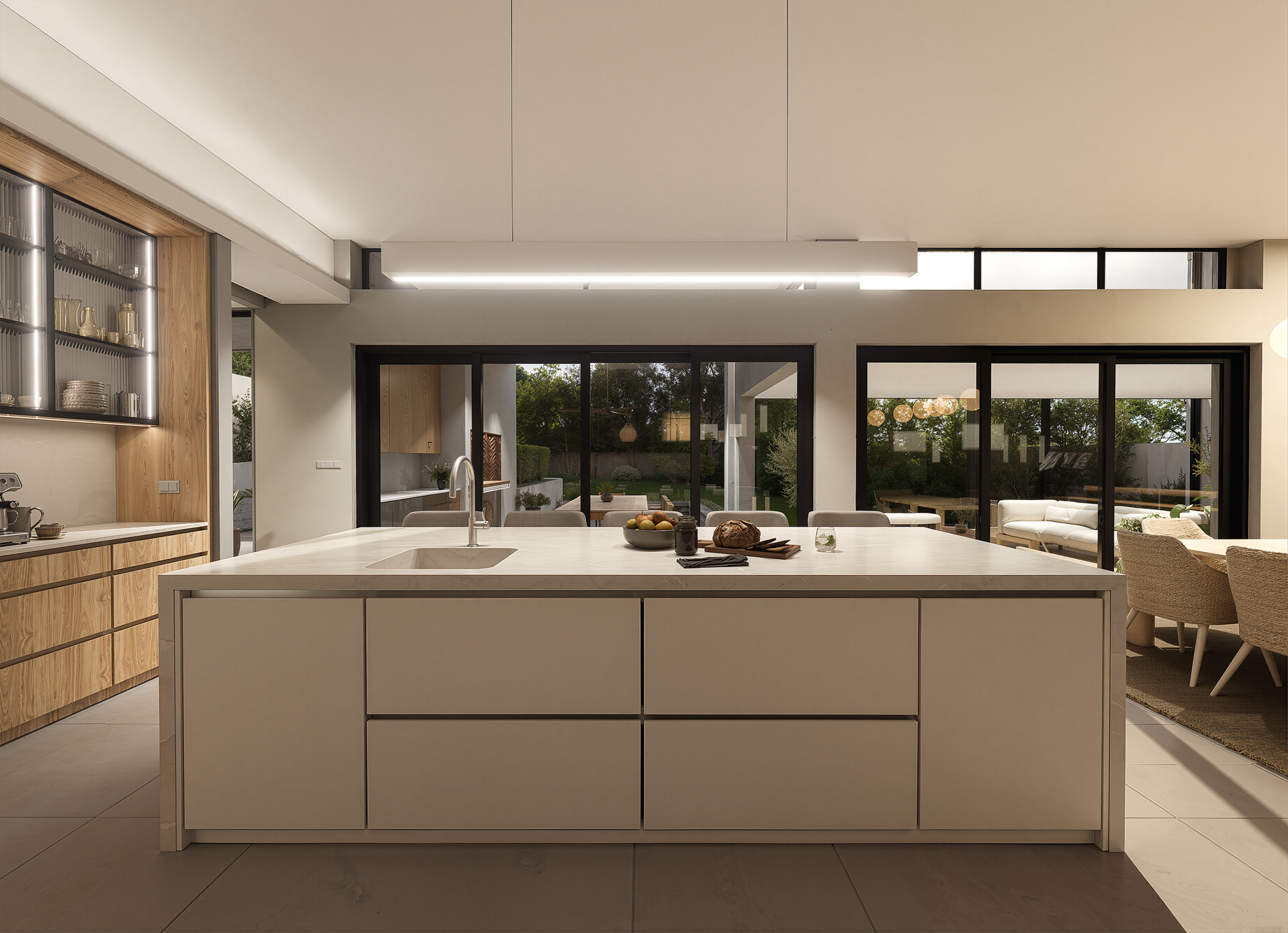 View from behind a white kitchen island showing a built-in sink looking out towards large glass doors and the patio.