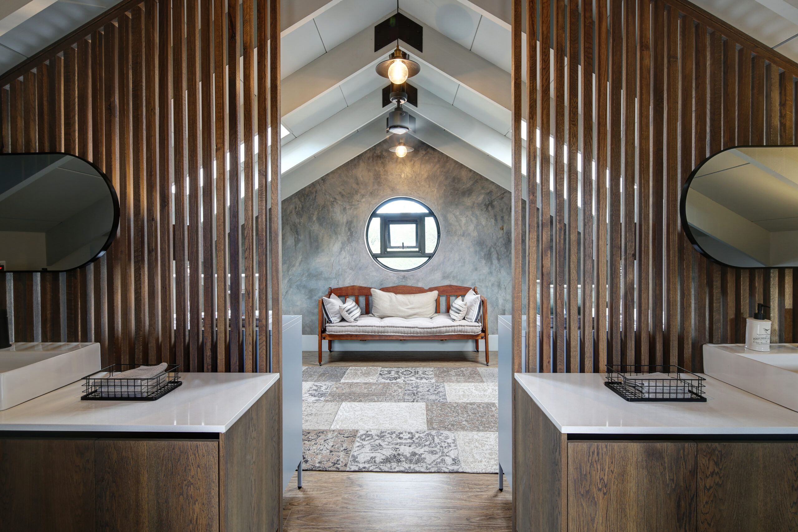 Guest bathroom ensuite with wooden privacy screens and view of porthole window