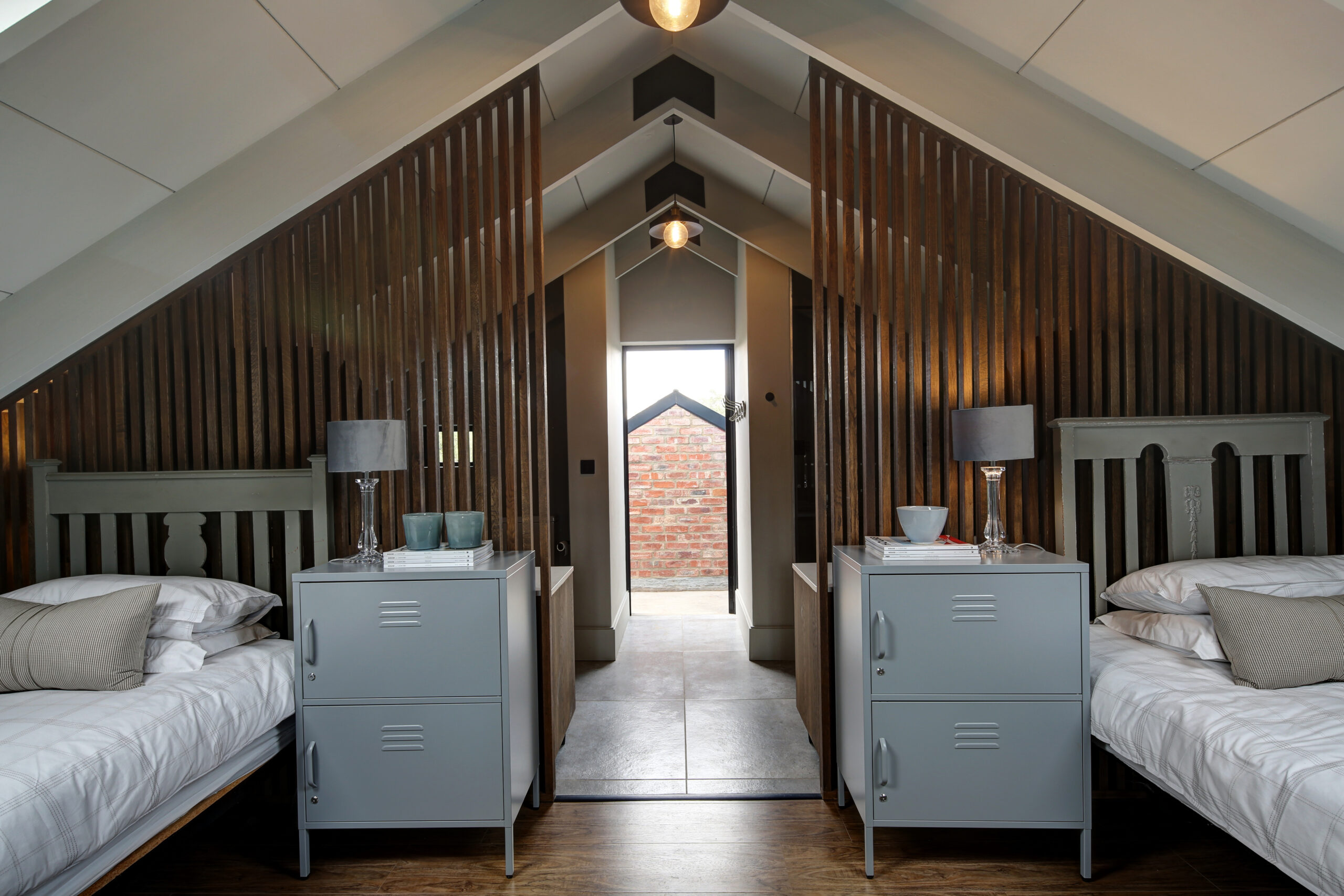 Guest bedroom with wooden privacy screens and view of outdoor exposed outdoor stockbrick shower