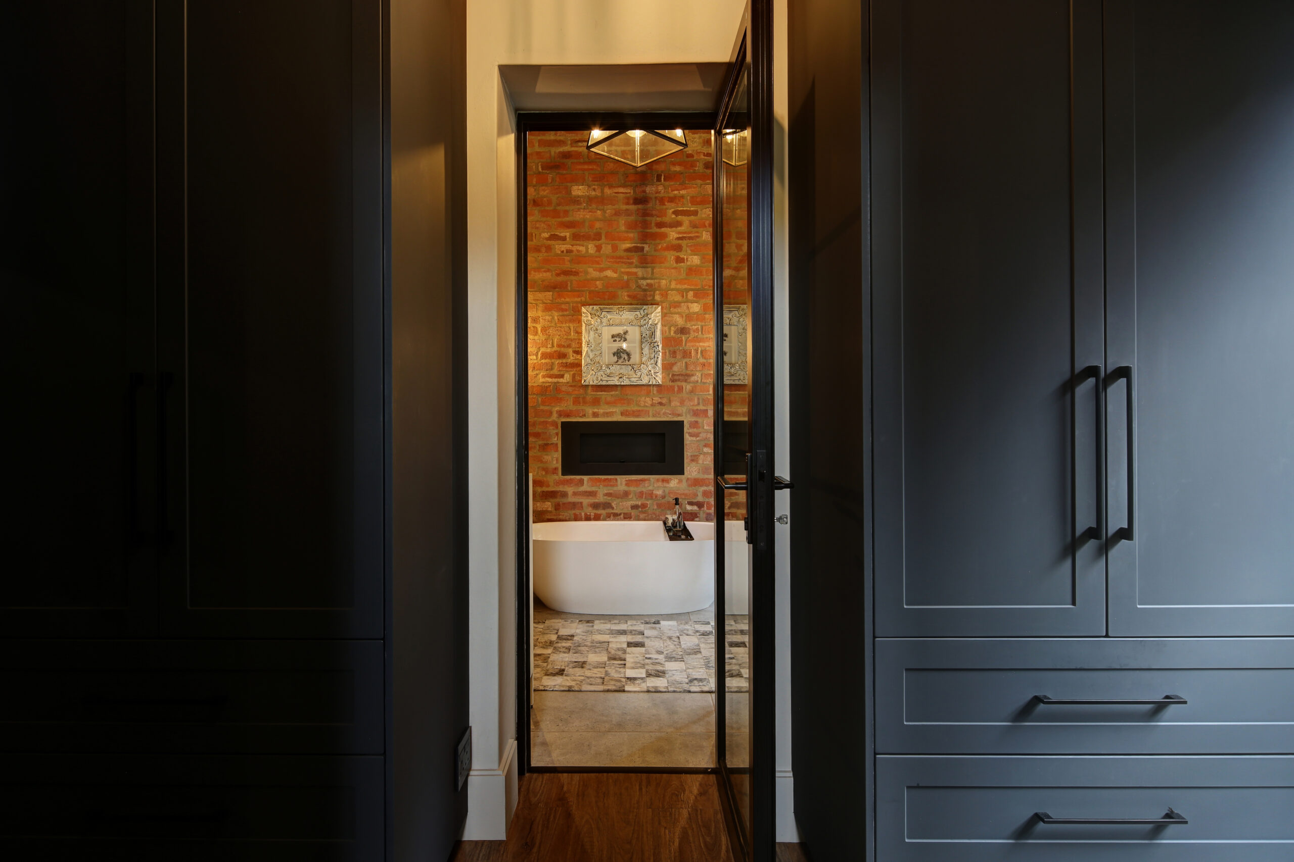 View of en-suite bathroom with stock brick wall from the dressing room